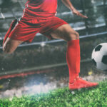 Soccer player kicks the ball vigorously at the stadium